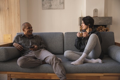 happy-young-multiracial-couple-taking-on-sofa-at-home-4049517