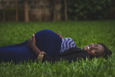 pregnant-woman-lying-on-green-grass-fields-2781219