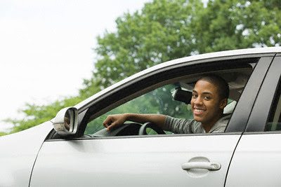 Smiling Young Man Driving --- Image by © Image Source/Corbis