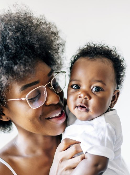 An African-American mother taking care and loving her baby against a white background